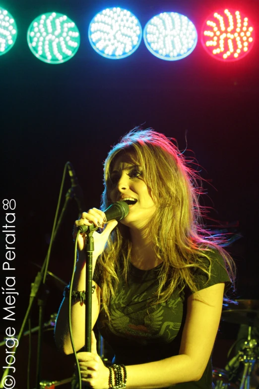 a woman singing in a microphone on stage