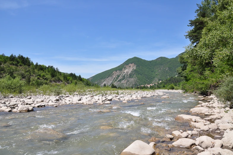 a river that is near some mountains in the distance