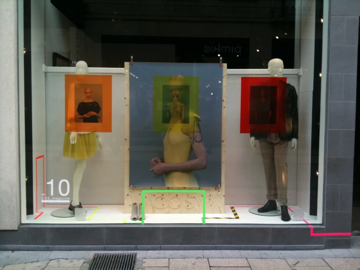 a window display that displays some mannequins with art works