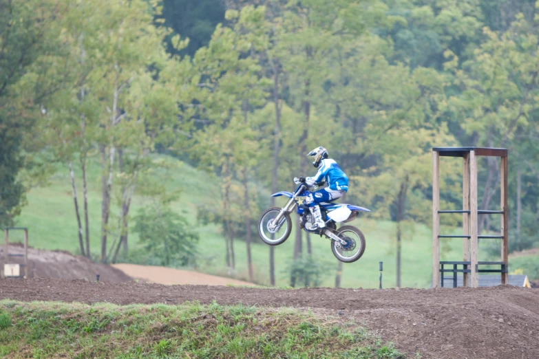 a person jumping a motorcycle over a dirt hill