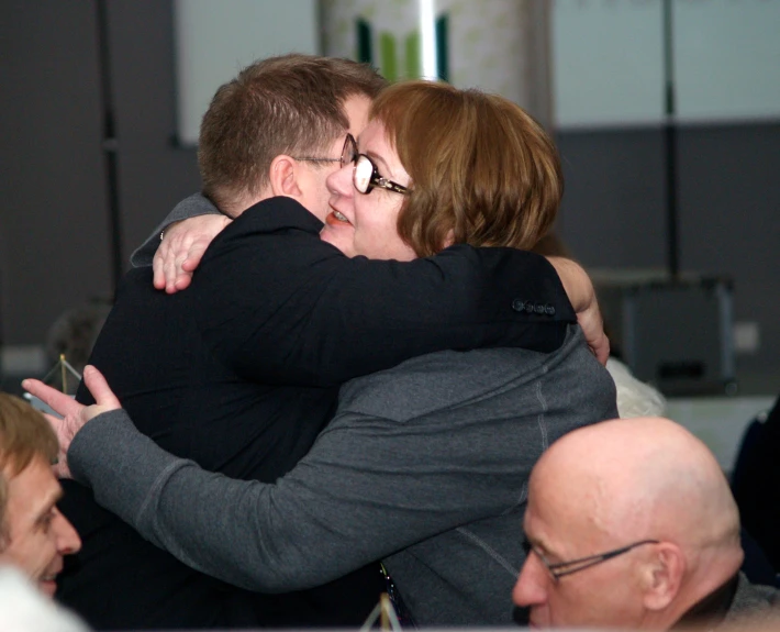a man and woman hugging at a public gathering
