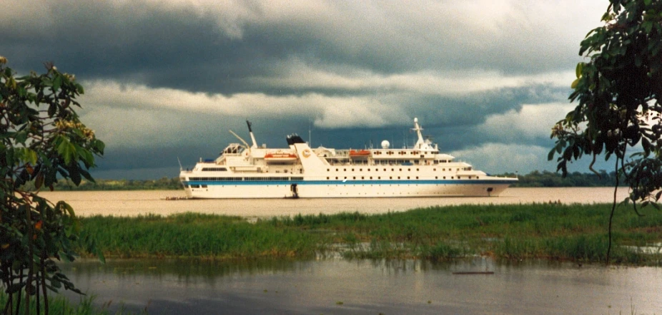 the large white ship is traveling down the river