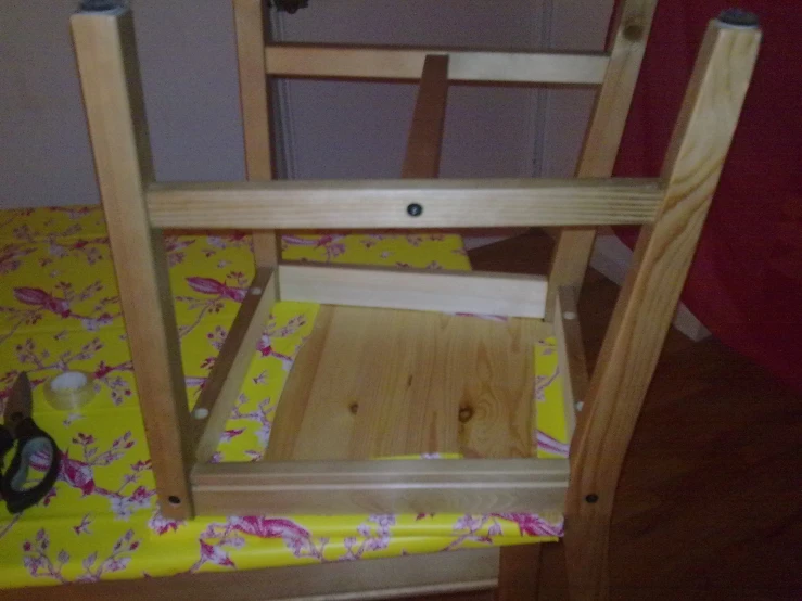 a doll house wooden chair is next to a bed