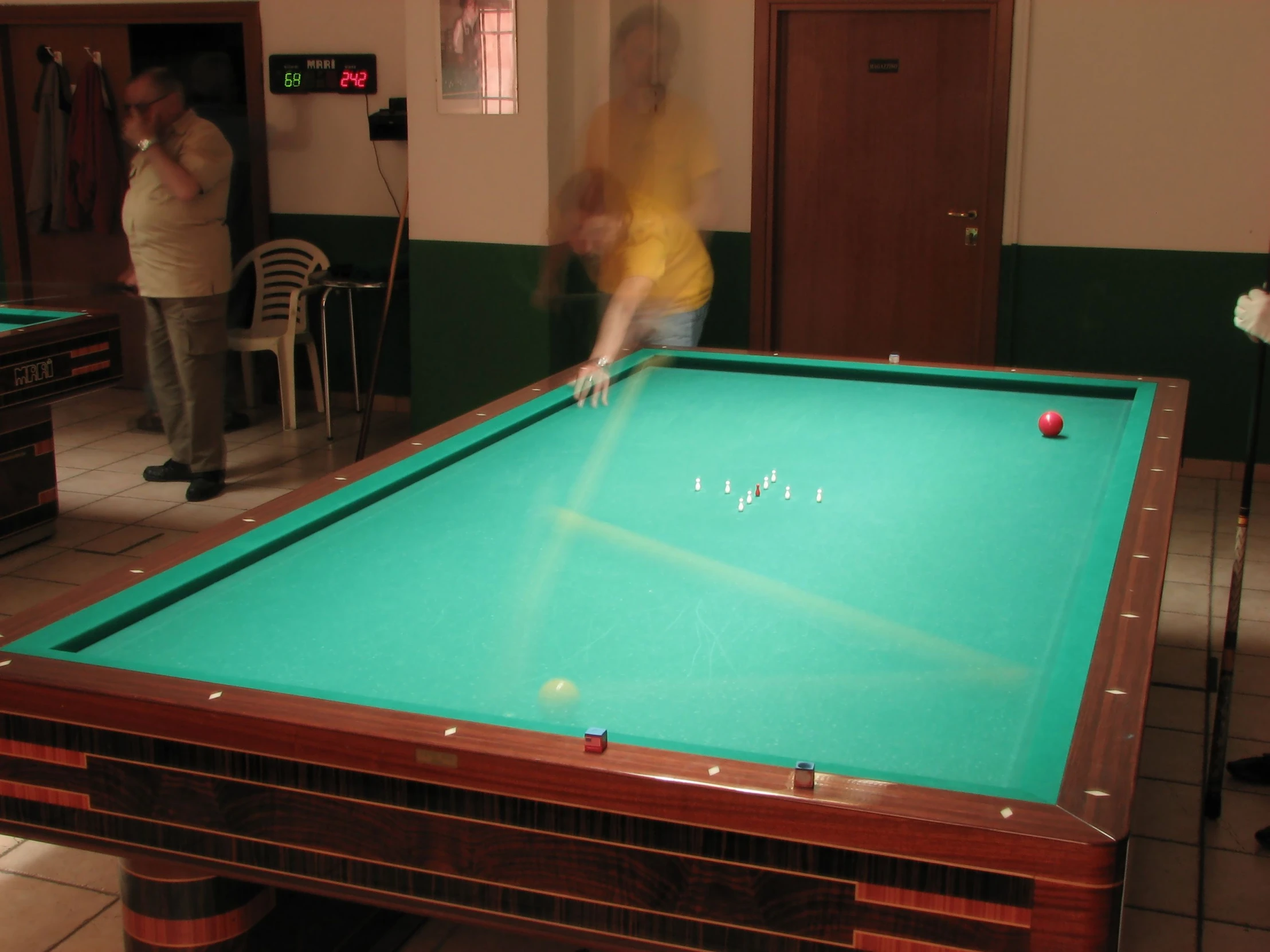 the woman in the yellow shirt is playing pool