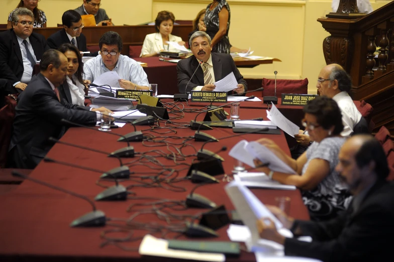 people sitting around a table with several papers