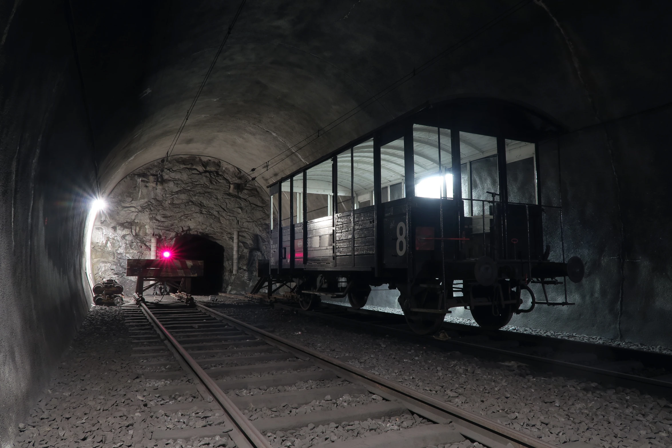 a train is pulling into a dark tunnel with lights