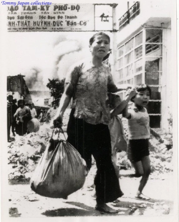 old black and white pograph of women carrying bags