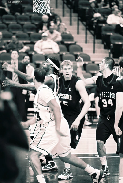 black and white pograph of basketball game with player blocking ball