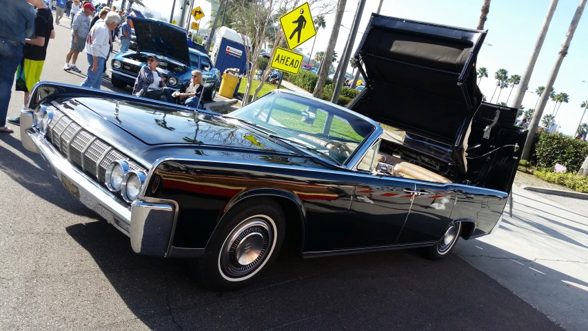 the old fashioned car is parked near the curb