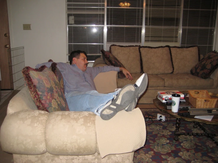 a man sitting on top of a couch holding a cardboard box