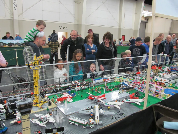 a group of people standing around a lego table