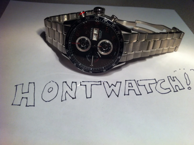 there is a watch with writing on a napkin