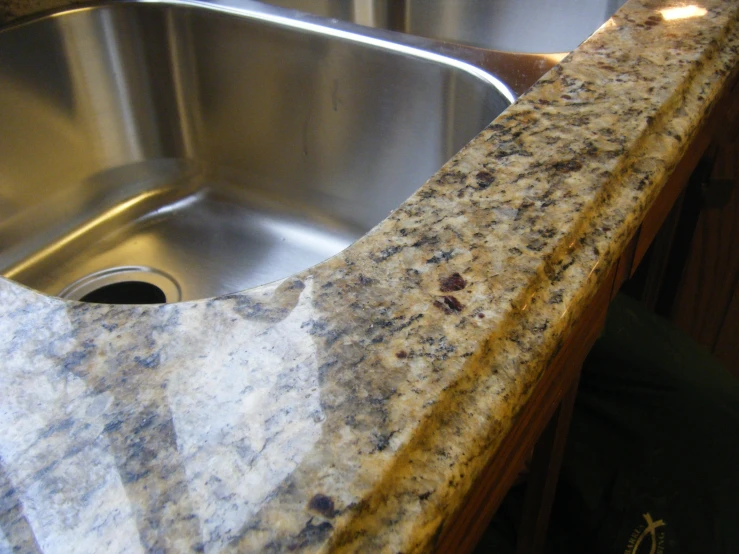 a granite counter top sits above a stainless steel sink