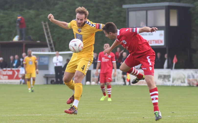 two players fight for the ball while others watch