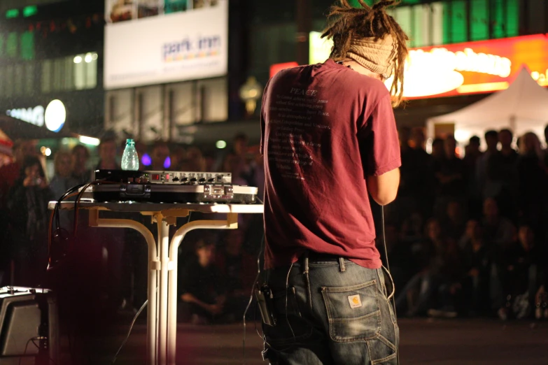 a man stands at a stage, while listening to music