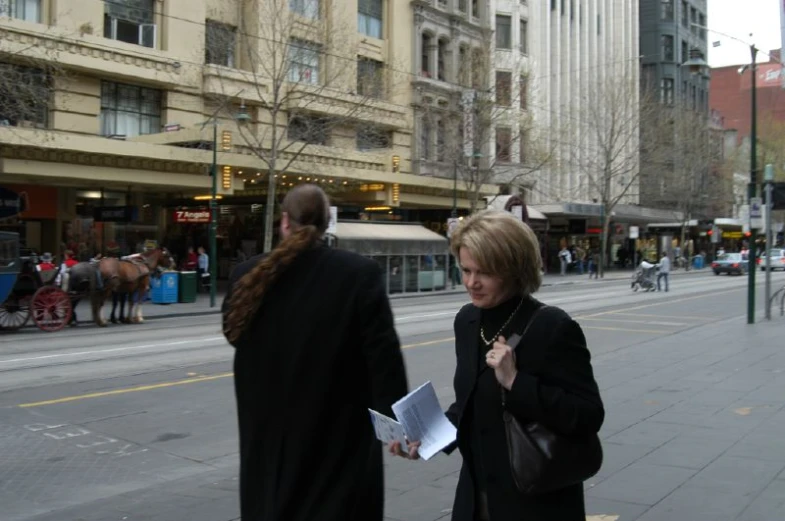 two people that are talking to each other on the street