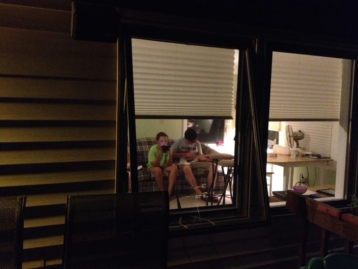 two young ladies sit outside the kitchen window