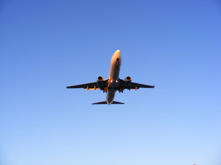 a large passenger airplane flying across a clear blue sky