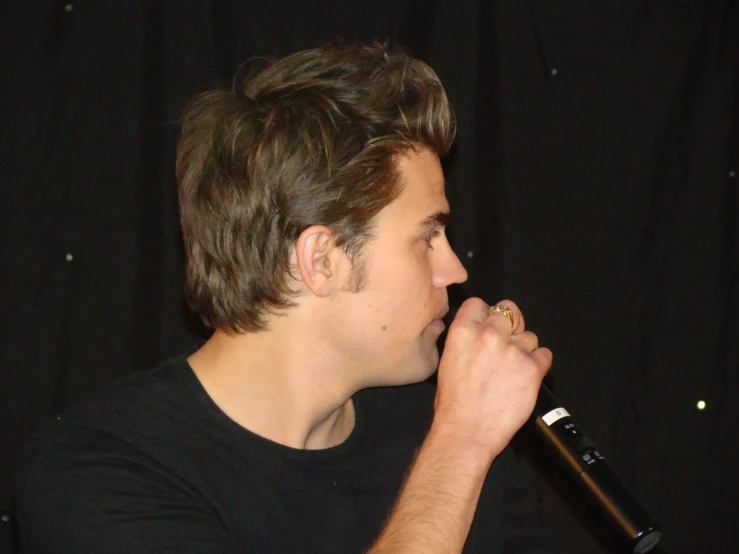 the man has a microphone to his ear