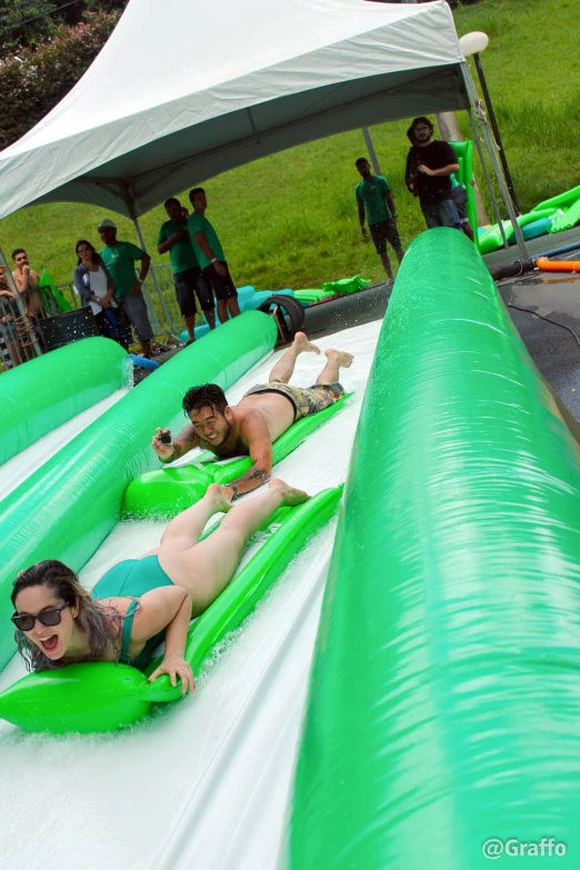 a couple on an inflatable pool slide