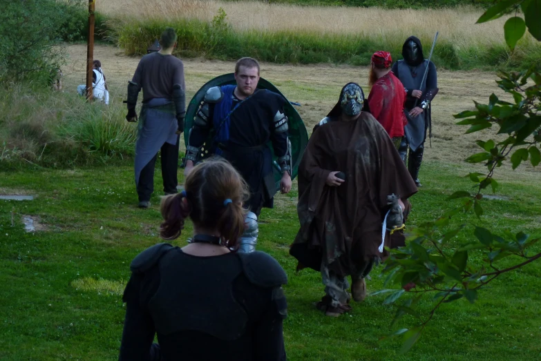 people walking in a field with many costumes on