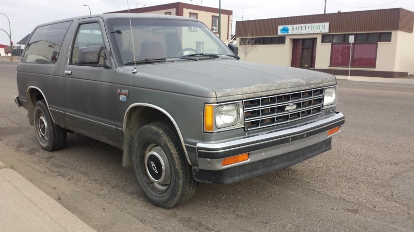 a pick up truck parked on a street with other cars parked behind it