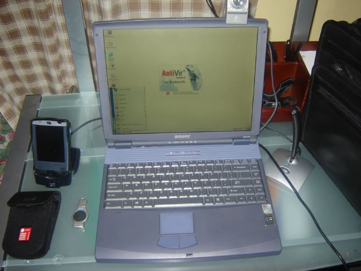 the laptop computer is on the table with other things