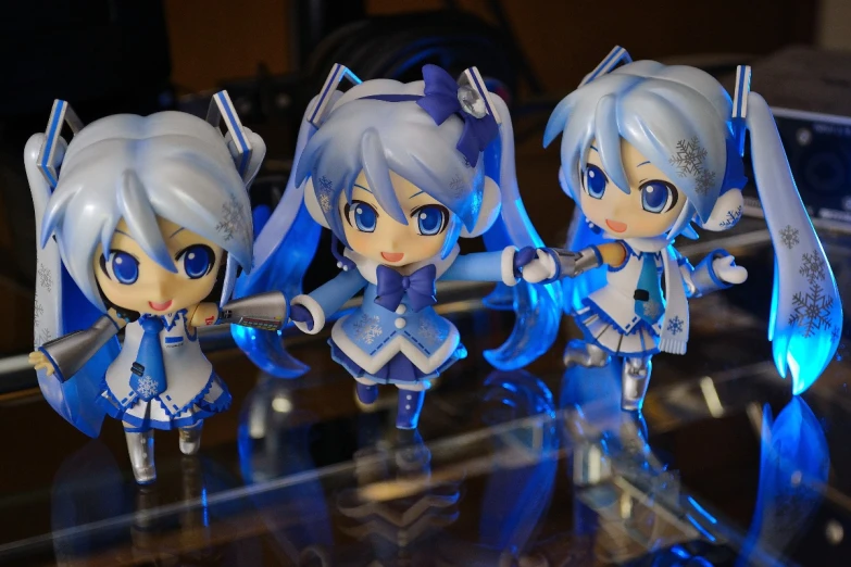 four plastic dolls are in a display case