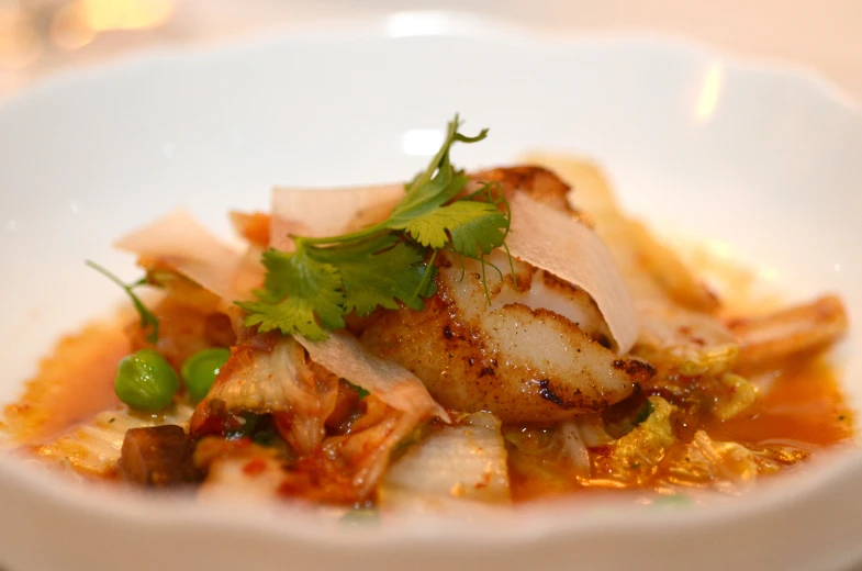 small plate filled with cooked seafood and vegetable topping