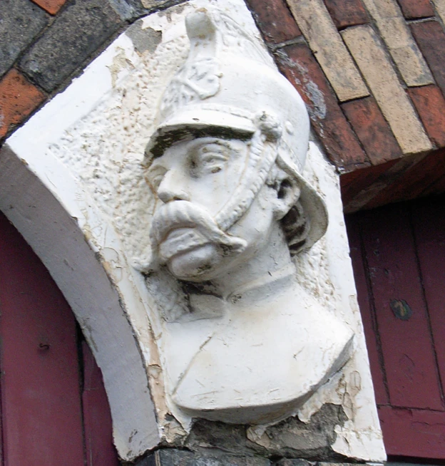 a busturine in a hat sitting on top of a building