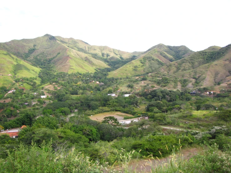 the scenic landscape shows mountains, fields and buildings