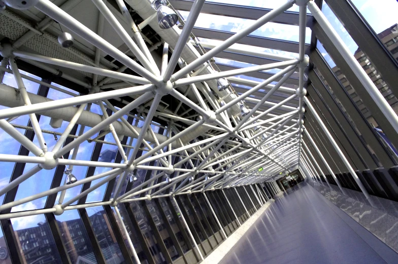 the walkway that leads to an elevated walkway is made up of several square, bent rails