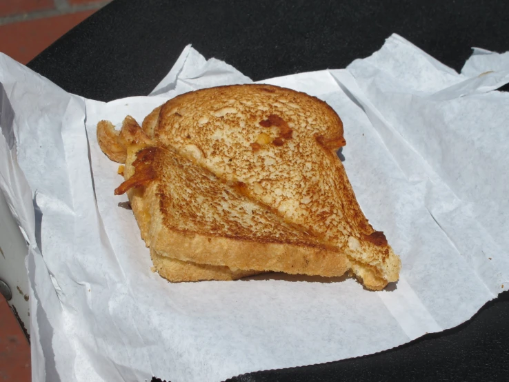 this is a grilled sandwich with mustard sitting on a table