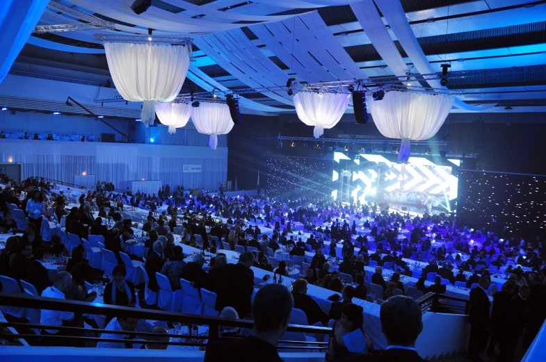 a bunch of people in a room with some blue lights