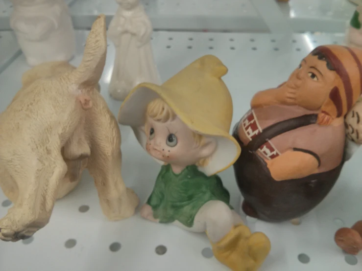 many figurines and toy animals on display with a glass case