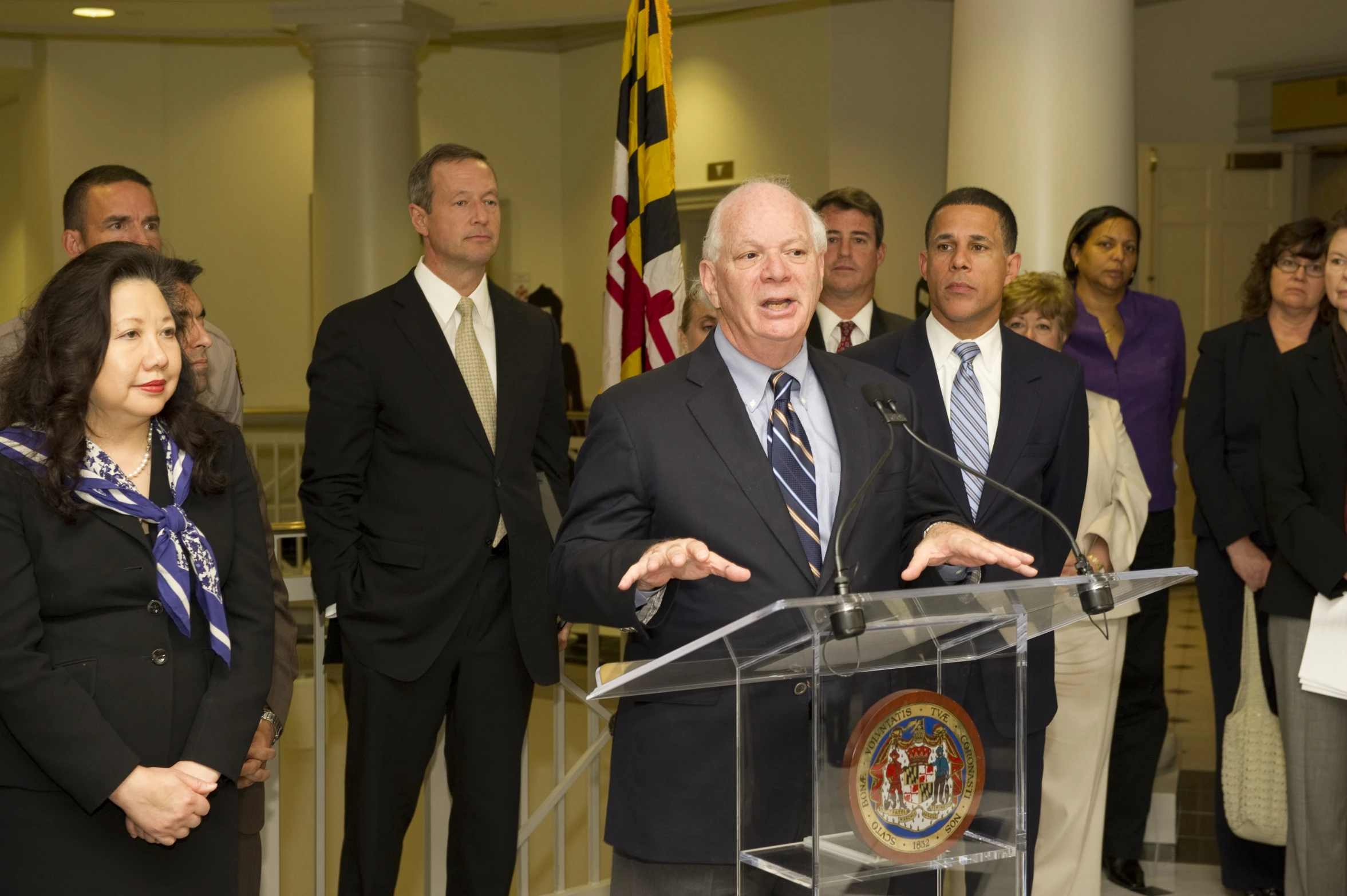 man speaking from behind a podium in front of a crowd