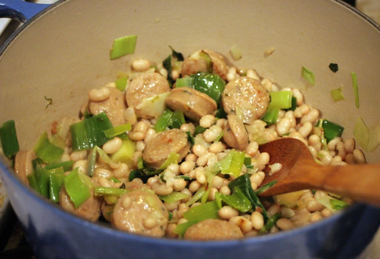 food in a blue pot, with a wooden spoon