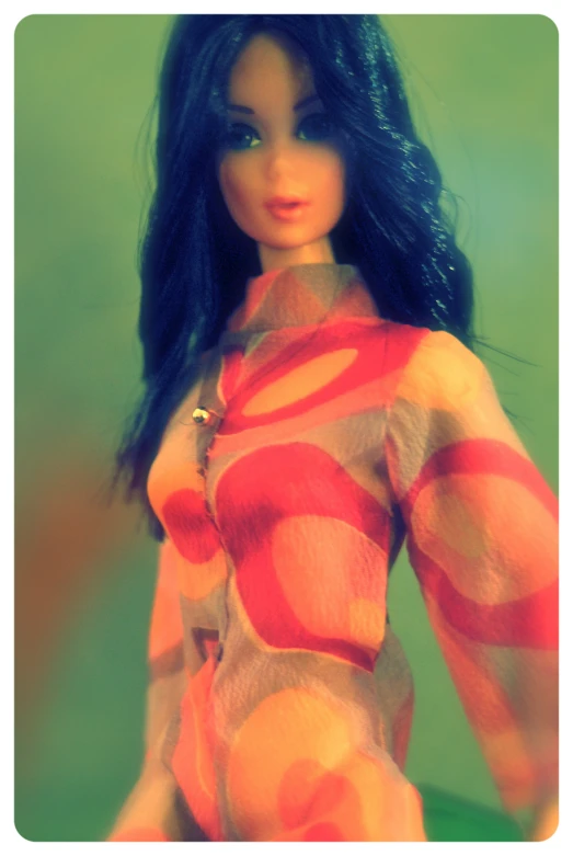 a very close up po of a barbie toy with a bright shirt