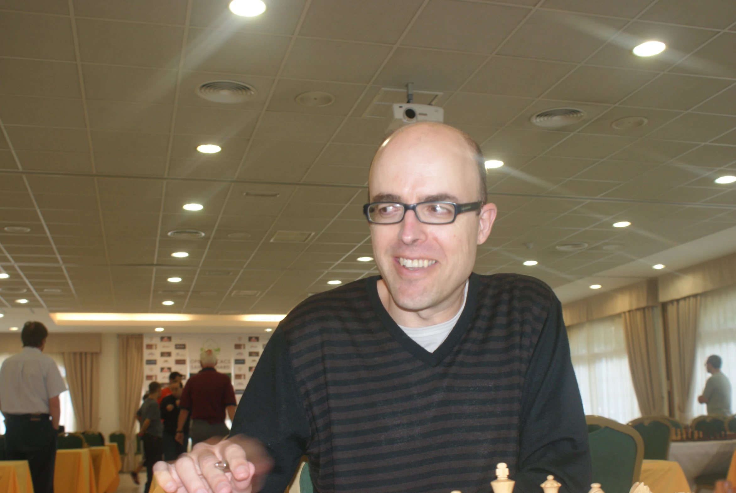 a man sitting at a chess table, smiling