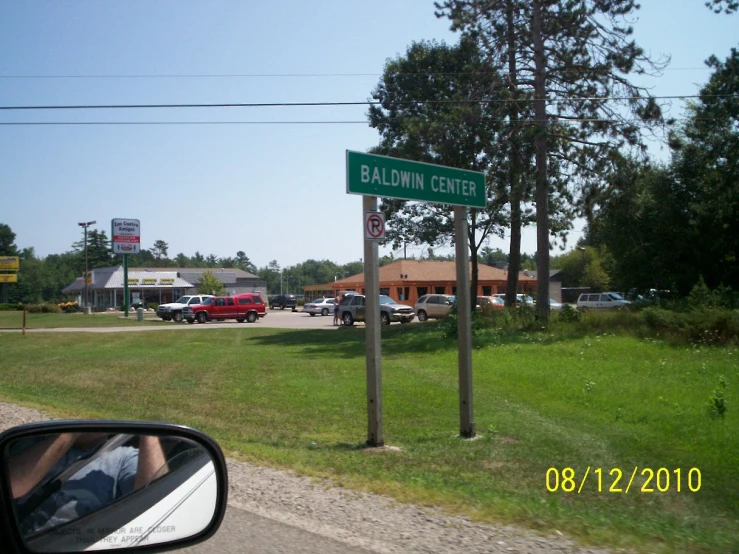 a road sign in a grassy field next to a street