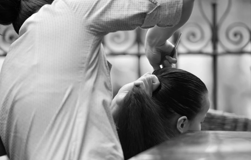 a woman bending over getting her hair cut