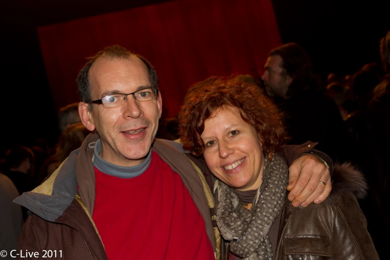 a man and woman are smiling at the camera