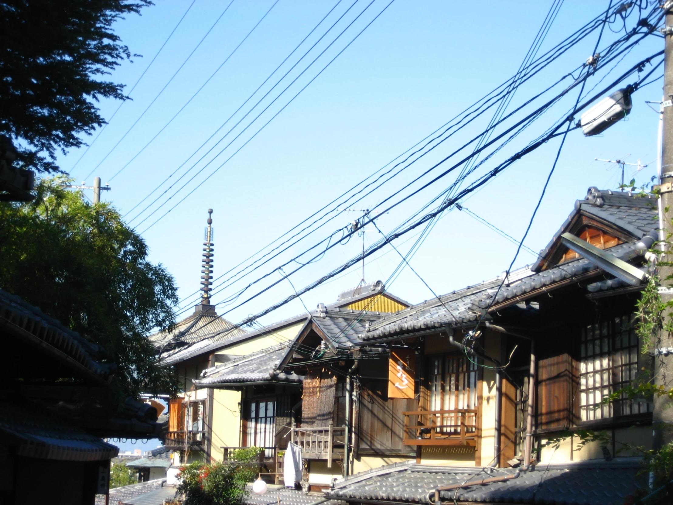 a brown and white wooden house with telephone wires above it