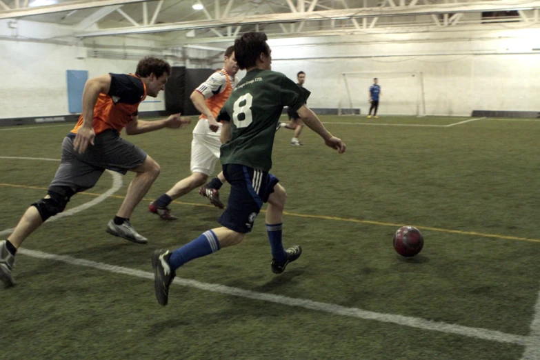 three soccer players fight for the ball in the field