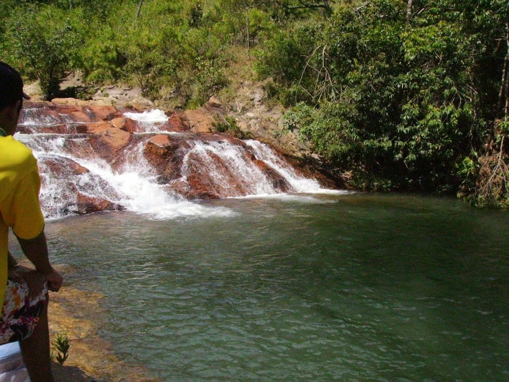 a man watching water fall from behind him