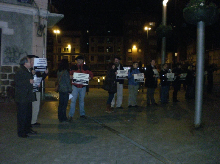 people holding signs on the street in a crowd