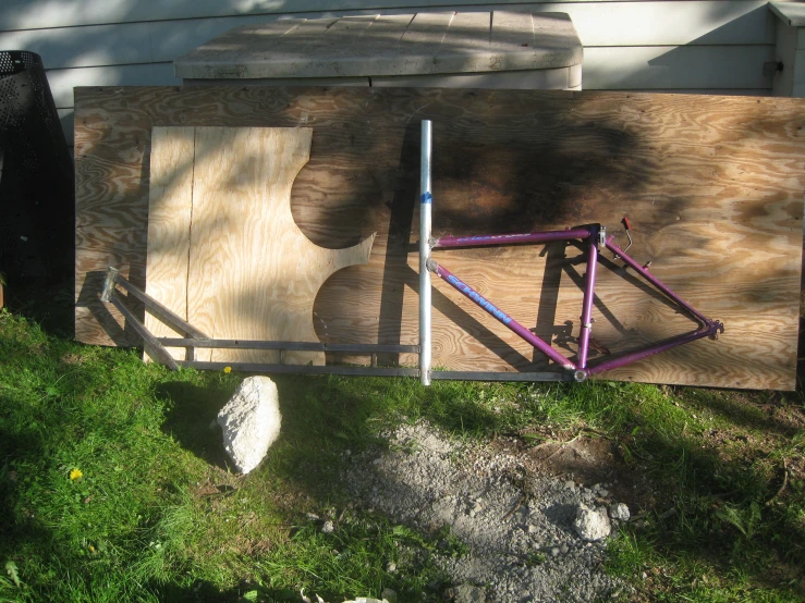 a bicycle is laying on the wood planks in the grass