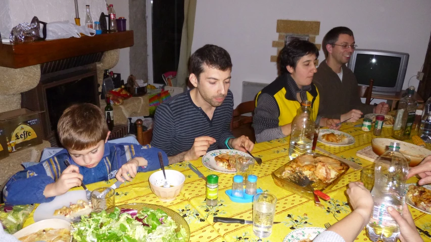 an adult and children eating at a table with family