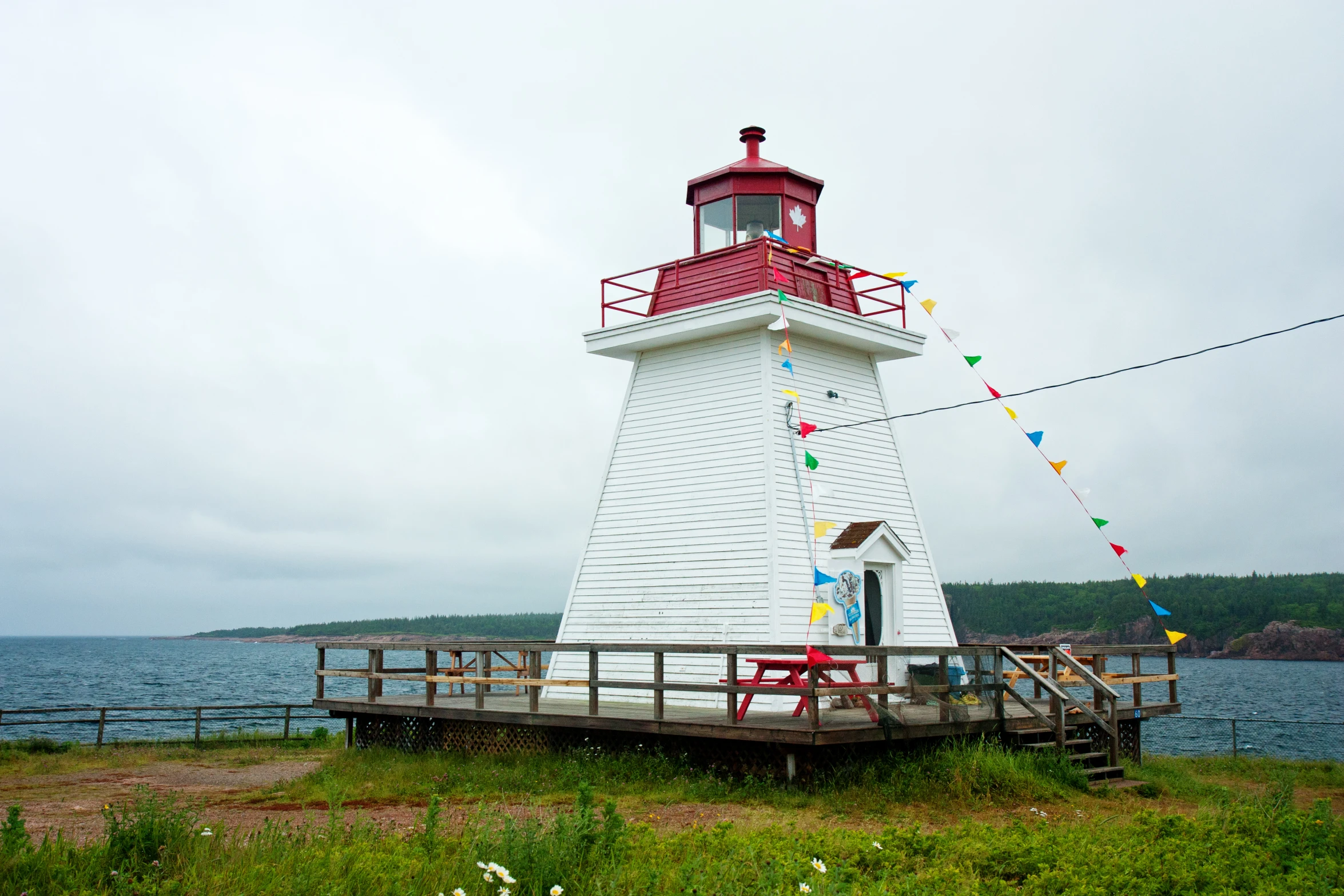 a lighthouse with a white roof sits near a body of water