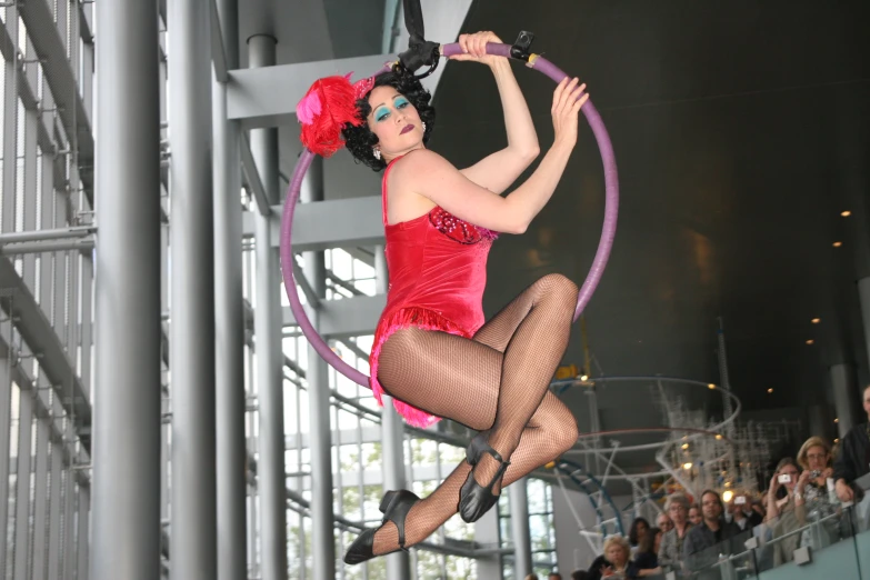 the woman in red is hooping on an aerial object